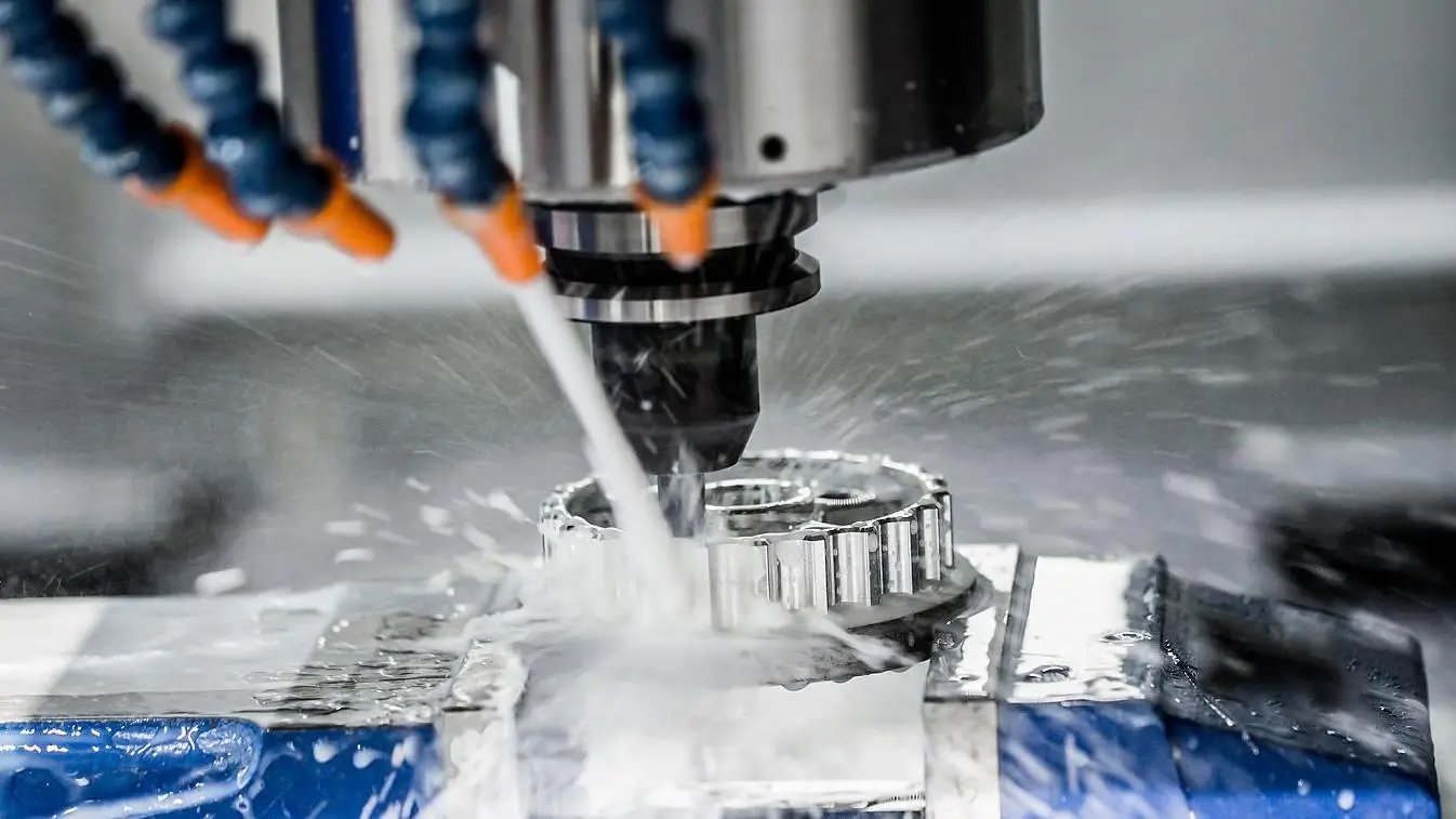 Close-up of CNC precision machining as a milling machine cuts a metal gear with coolant spraying.