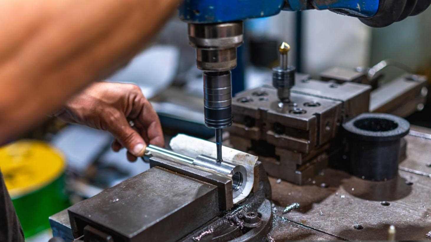 CNC operator milling a metal part on a precision machine in the workshop